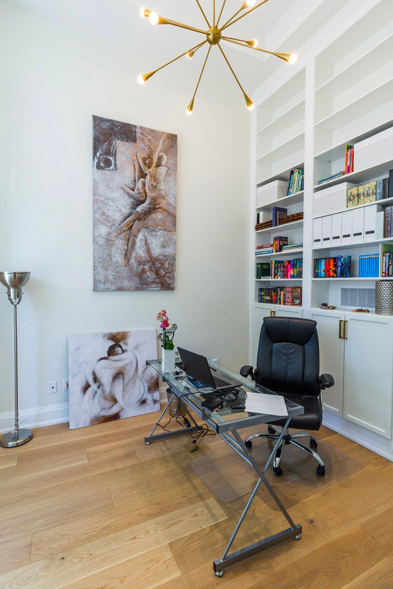 Home office with built-in shelving and brass sputnik chandelier