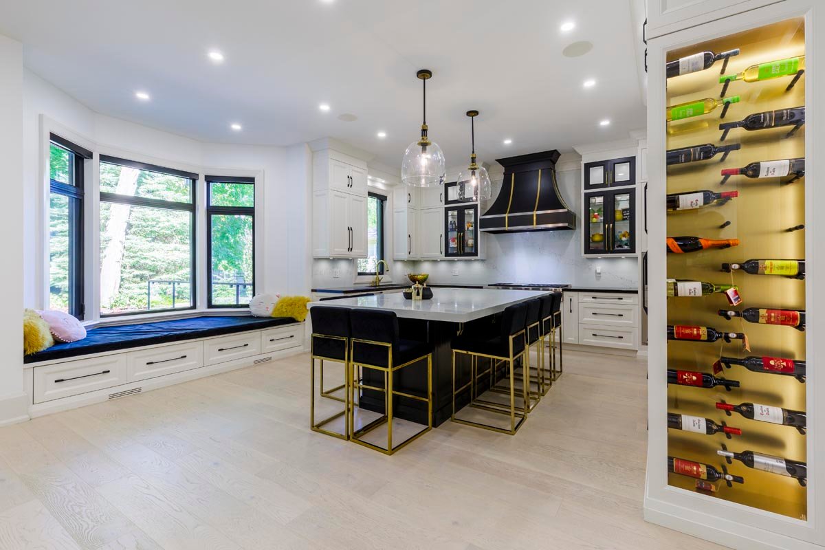 Kitchen with black island, gold wine display and bay window seat