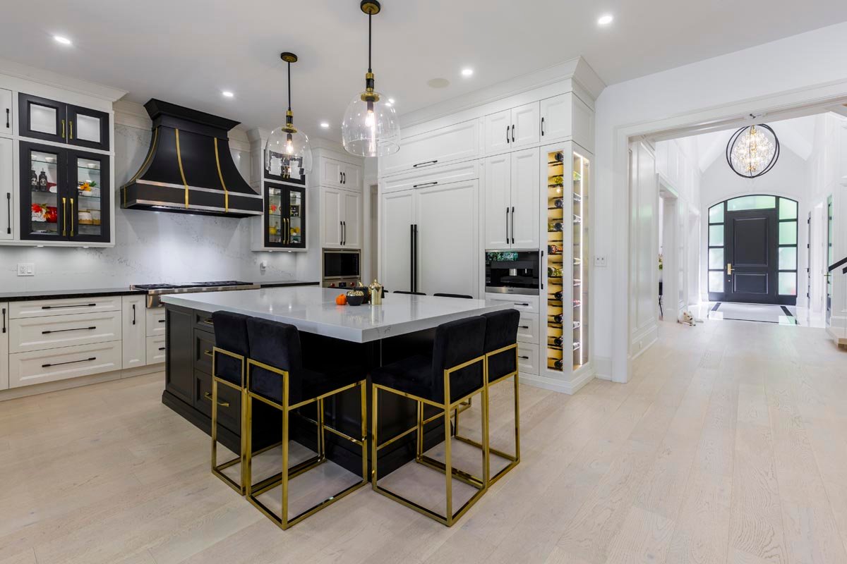 Kitchen with black and gold accents, island seating and custom hood