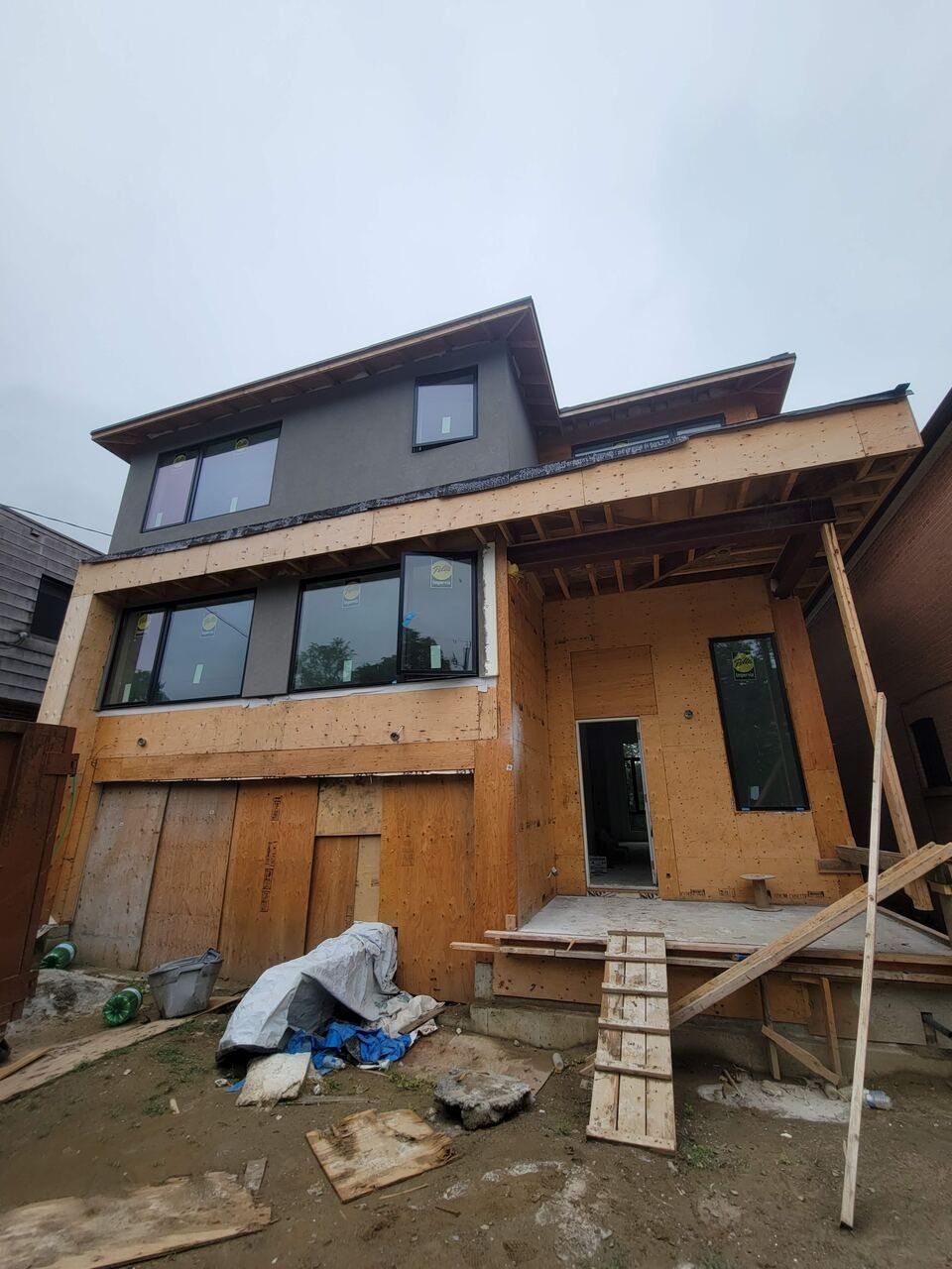 Rear of Lansing home during construction with framing and new windows installed