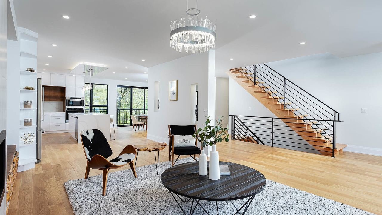 Open main floor with floating stairs and modern chandelier