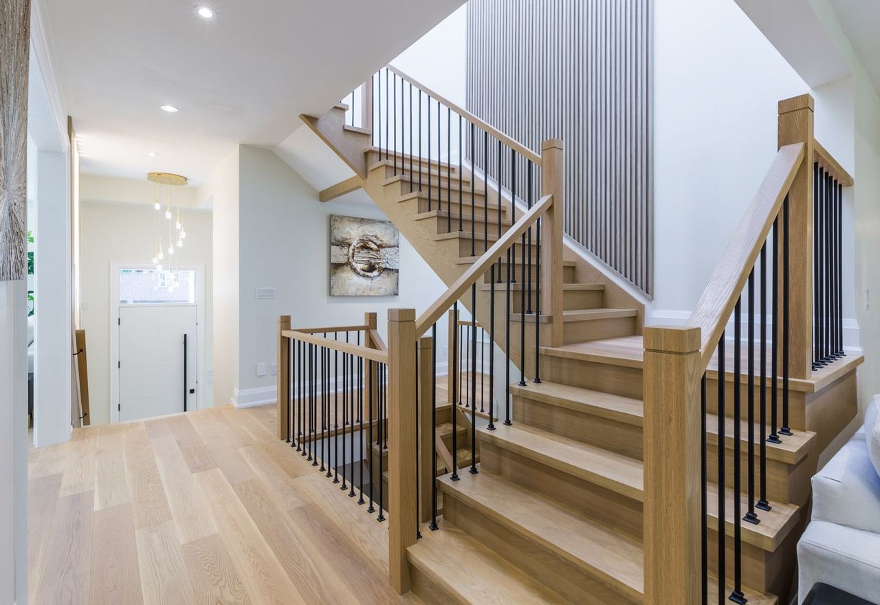 White oak staircase with black metal spindles and fluted accent wall