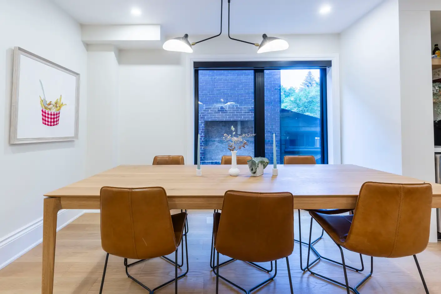 Dining room with white oak table, leather chairs and modern pendant light
