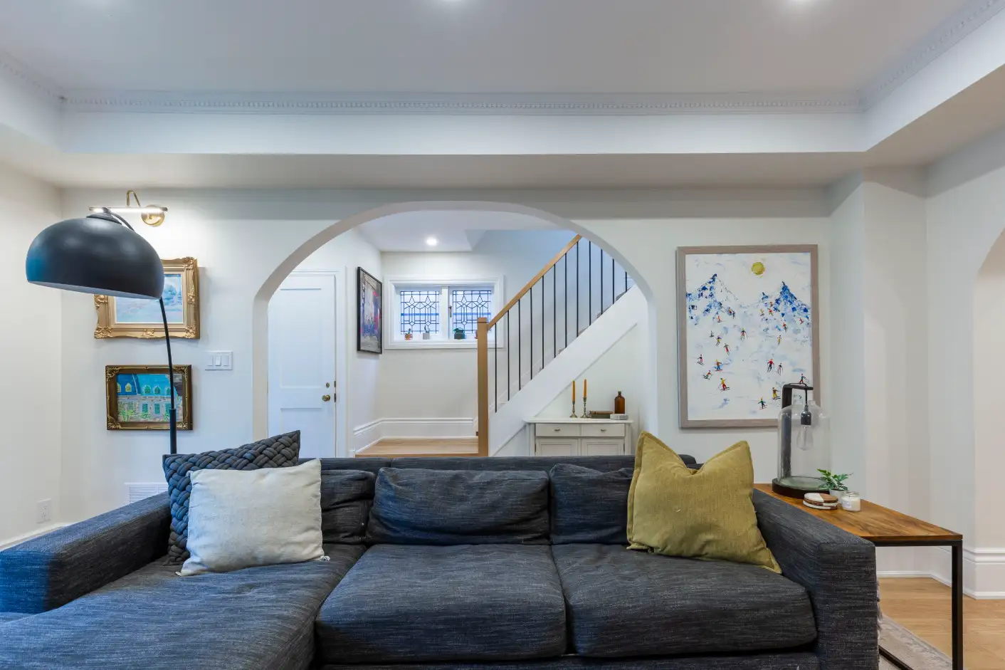 Family room with arched opening, crown moulding and new staircase with metal spindles
