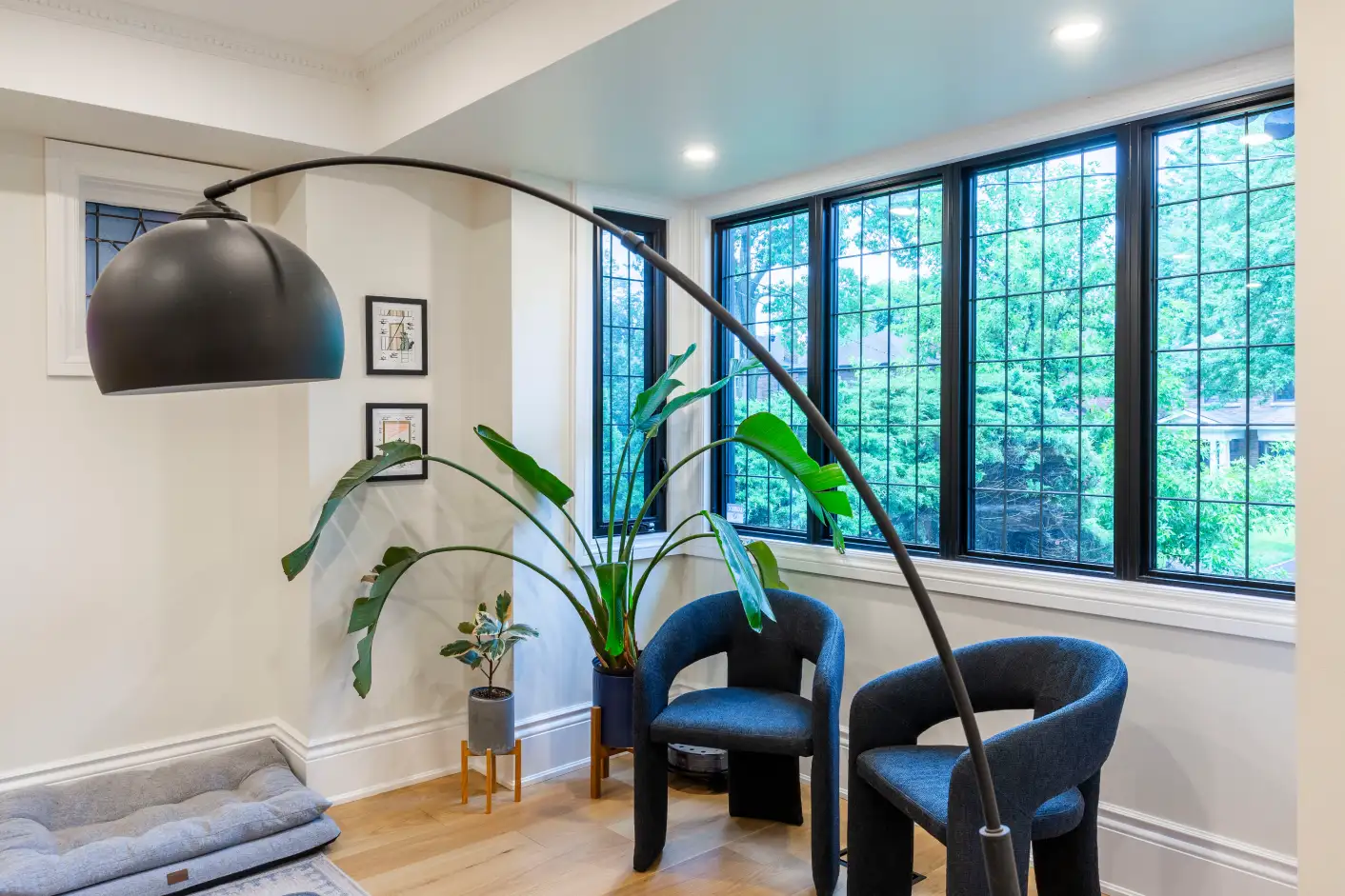 Sitting area with black-framed leaded windows and arc floor lamp