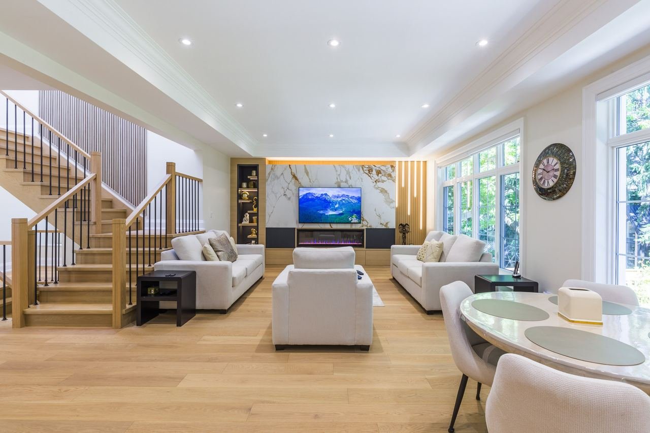Open concept main floor with white oak stairs and marble media wall