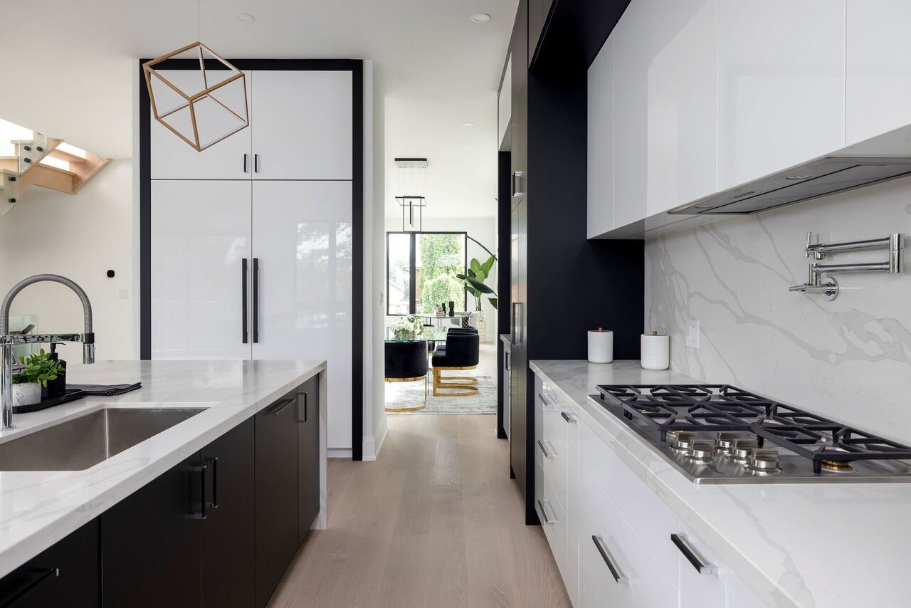 Galley kitchen with gas cooktop, pot filler and marble slab backsplash