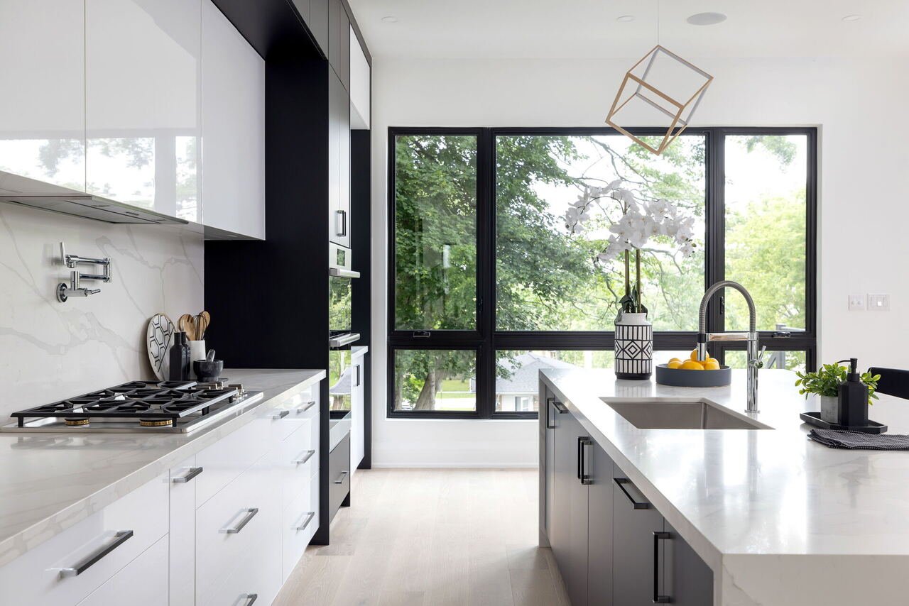 Kitchen with floor-to-ceiling windows, island sink and geometric pendant light