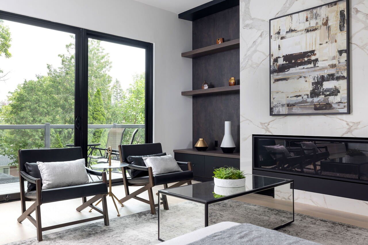Living room with linear gas fireplace, marble surround and walkout to balcony