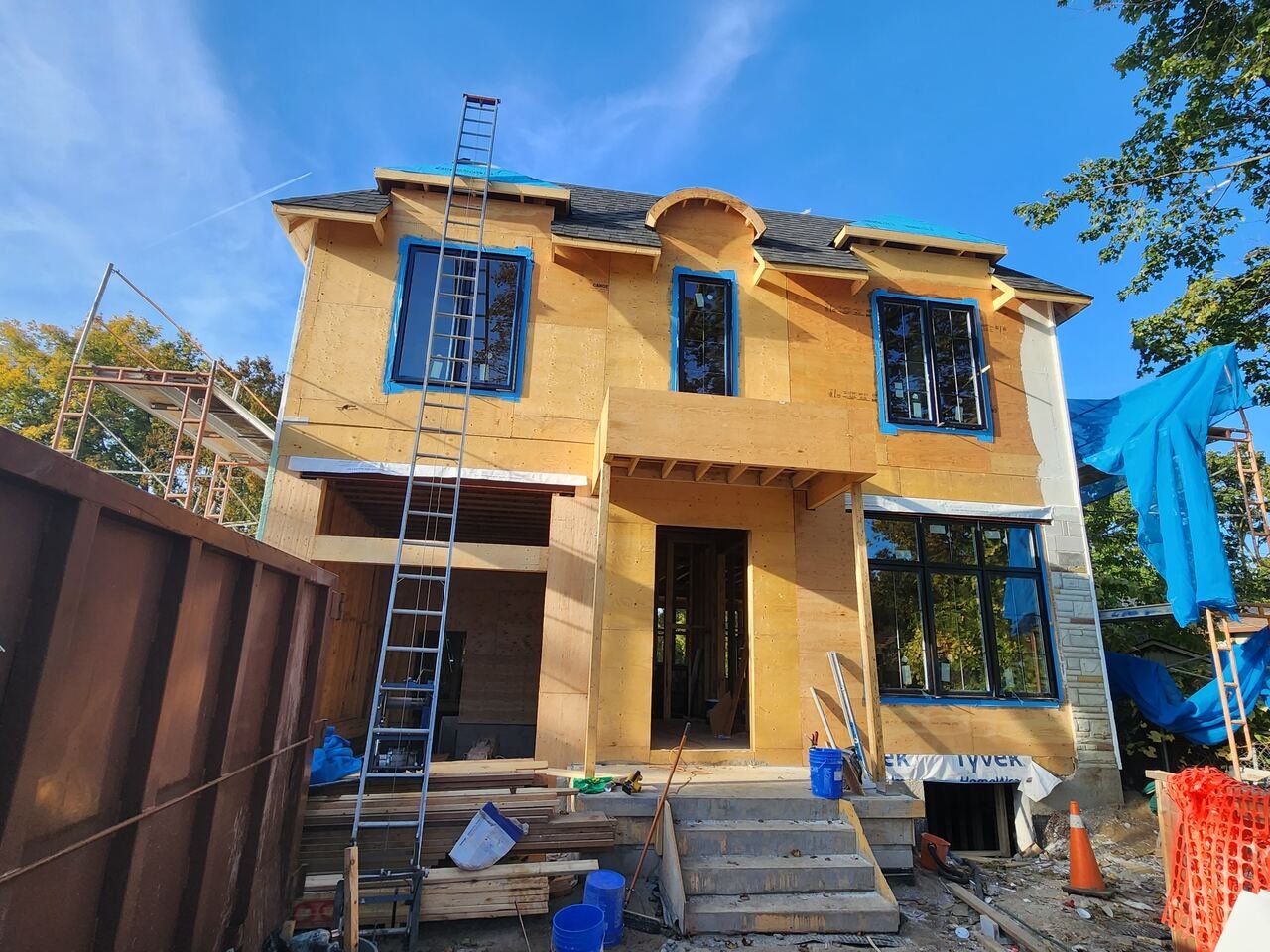 Front exterior with windows installed, roof shingled and portico framed