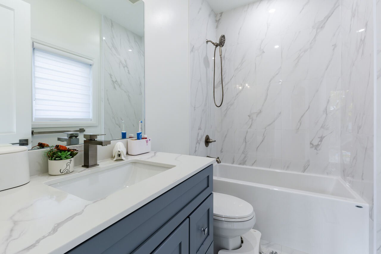 Primary ensuite with white oak double vanity, LED mirror and frameless glass shower