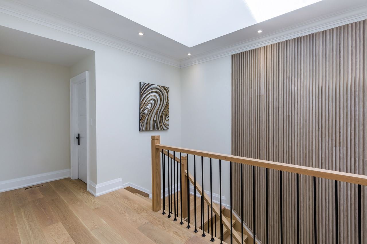 Upstairs hallway with skylight and fluted wood accent wall