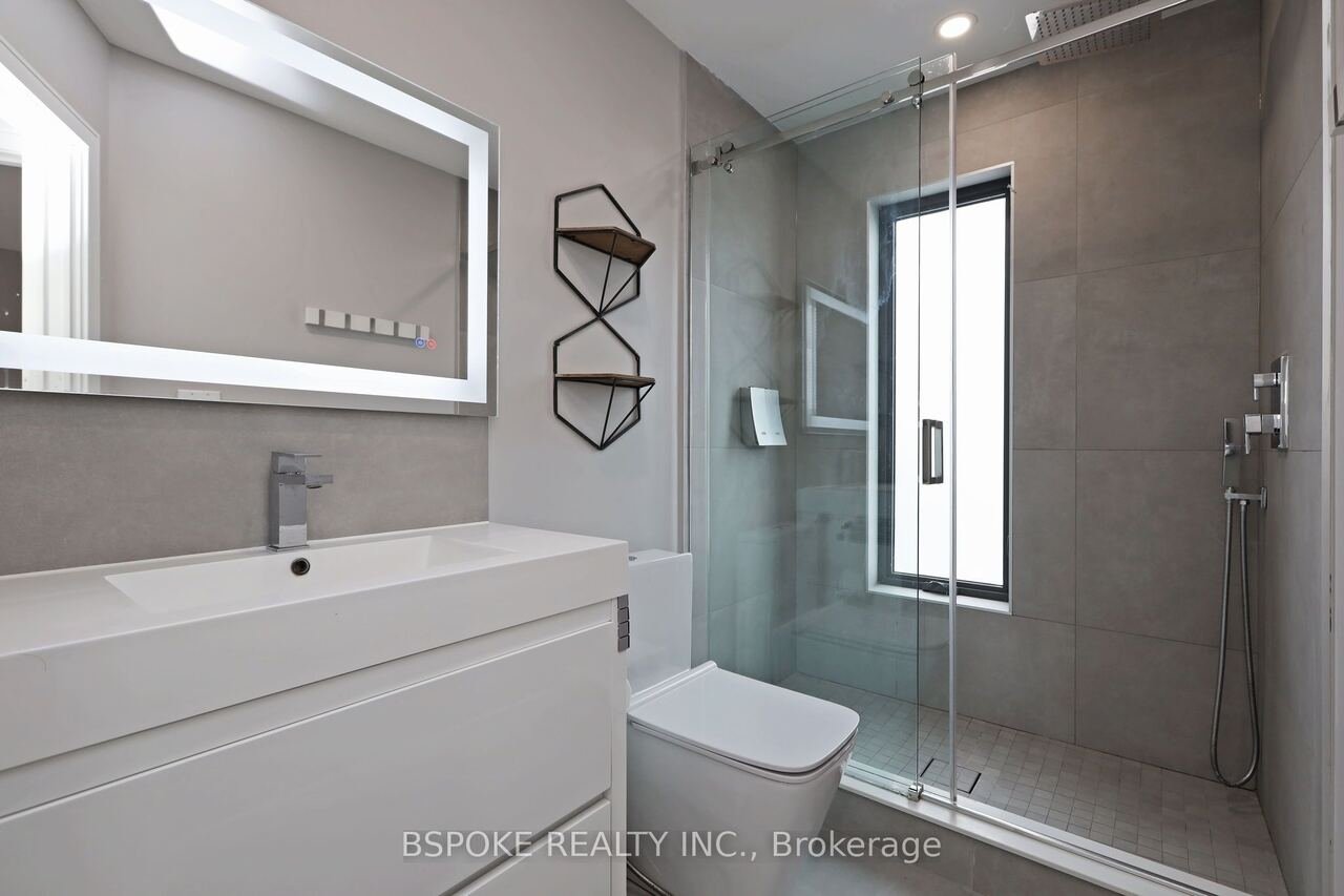 Bathroom with marble-tiled glass shower and LED mirror