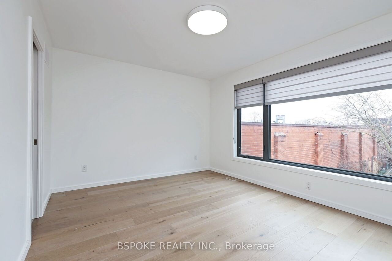 Bedroom with oversized picture window and white oak flooring