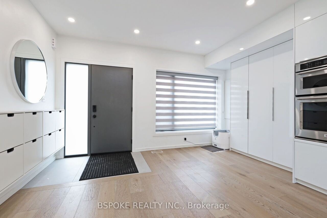 Front entry with built-in storage, round mirror and double wall ovens