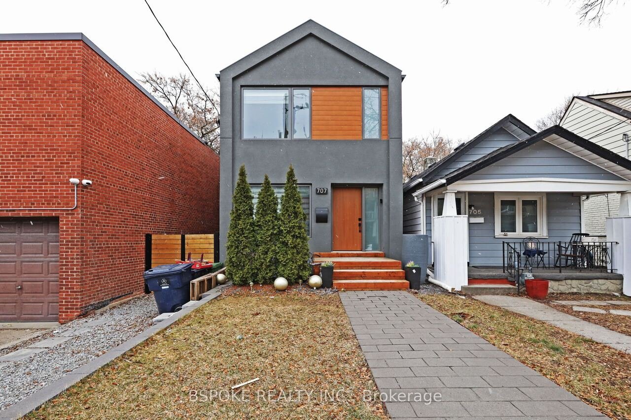 Modern grey stucco front exterior with cedar door and landscaped walkway