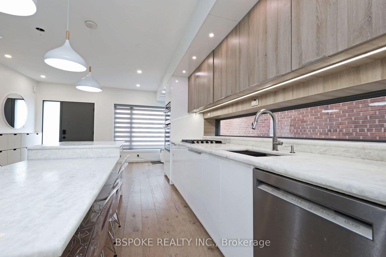 Galley kitchen with marble counters, gas cooktop and brick-view window backsplash