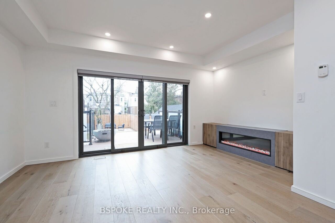 Living room with linear electric fireplace and sliding doors to the deck