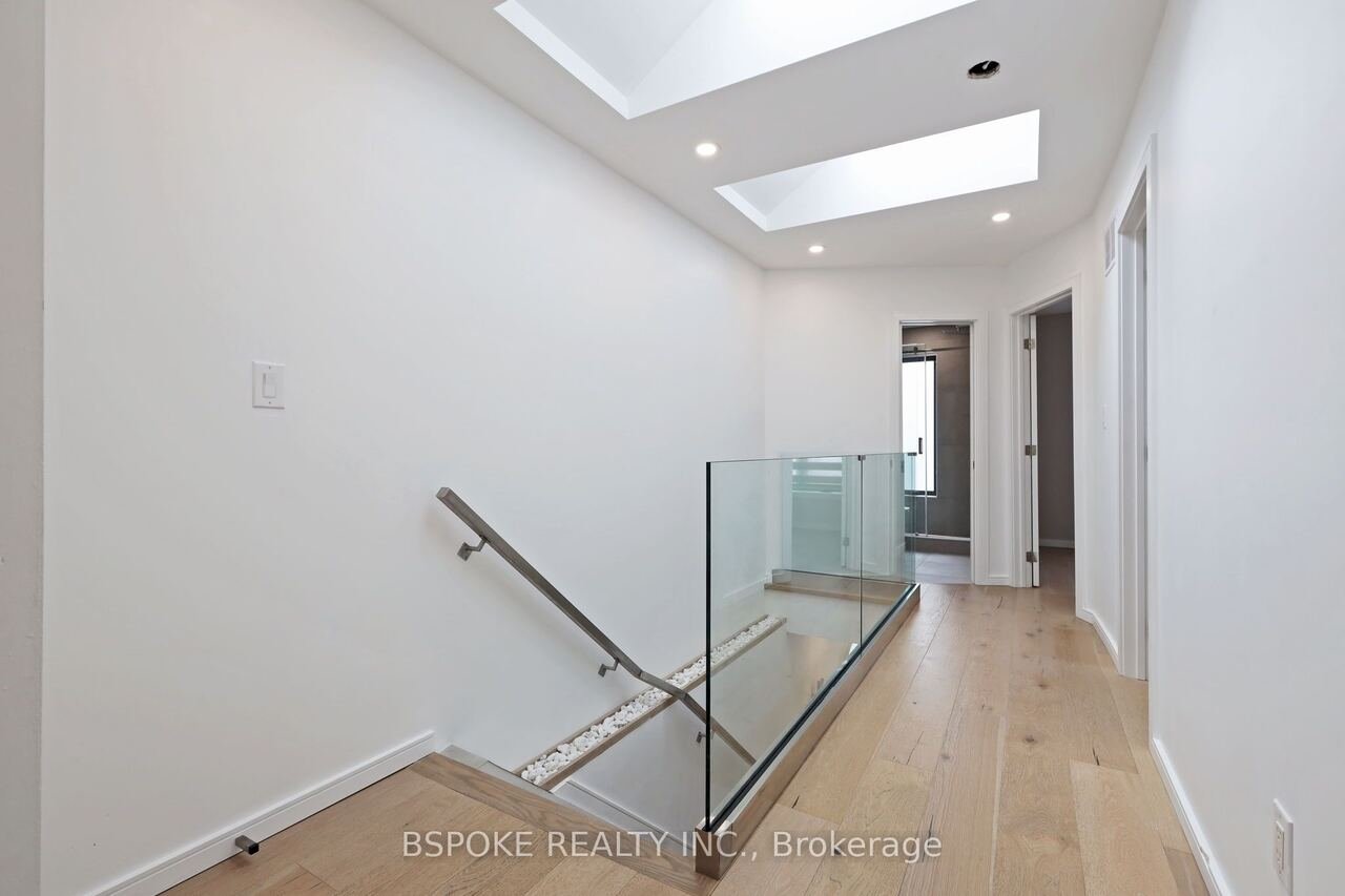 Upper hallway with two skylights and glass stair railing