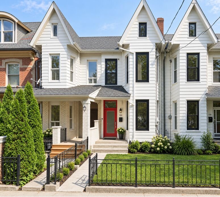 Restored Victorian semi-detached front exterior on Argyle in Toronto, with white siding, red front door and new landscaping