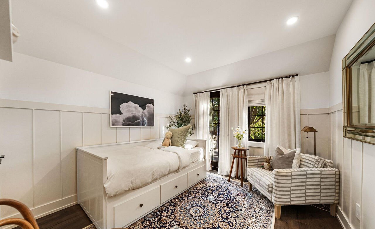 Children bedroom with white daybed, board and batten wainscoting and walkout to the rear balcony