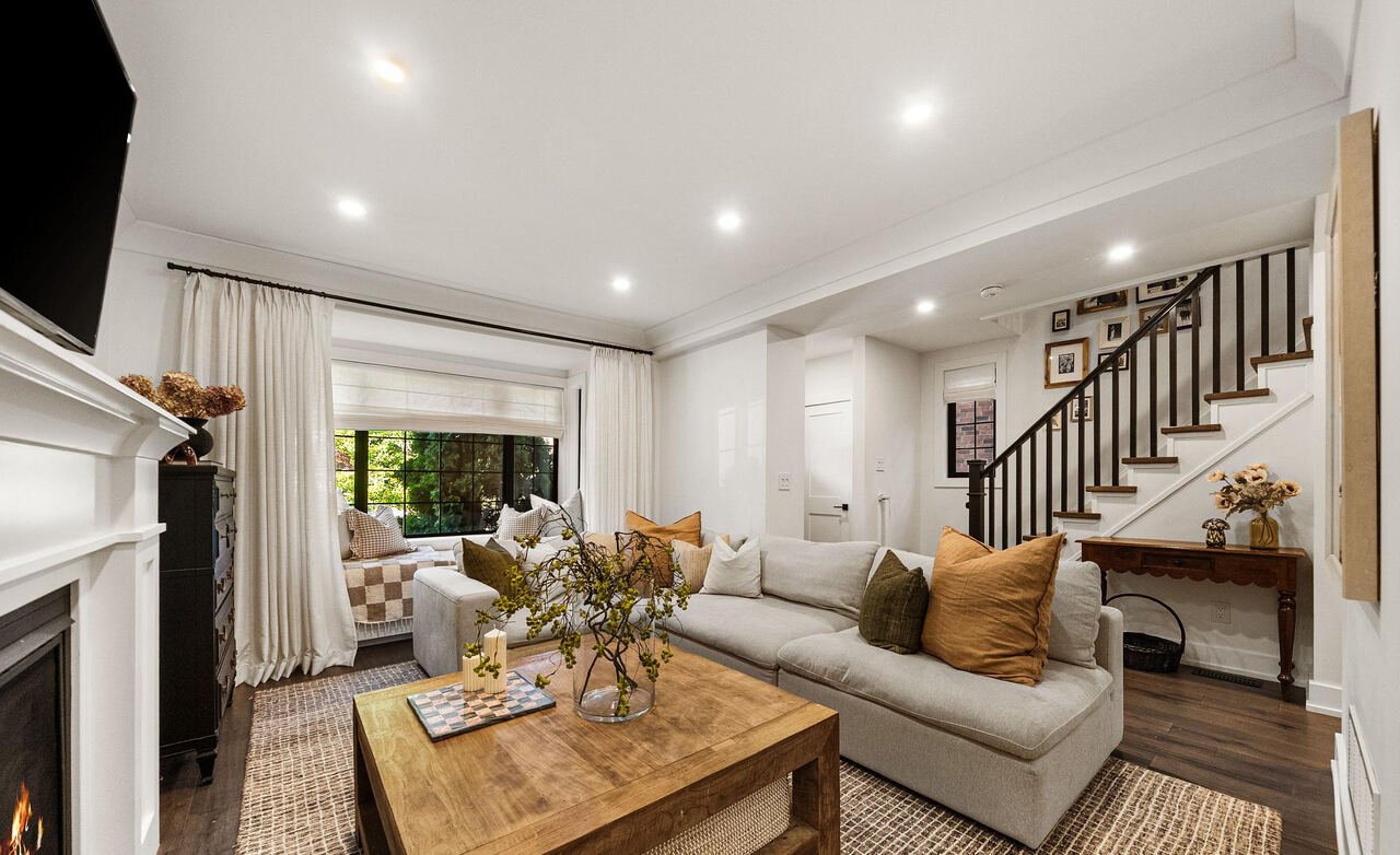 Living room with sectional sofa, bay window seat and view through to the staircase