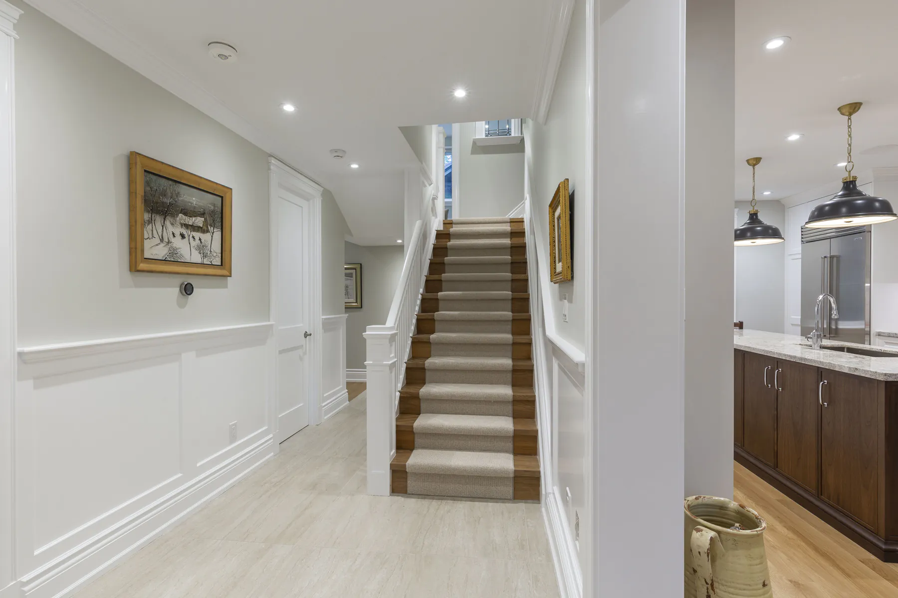 Renovated staircase with white hallway and wainscoting in Baby Point