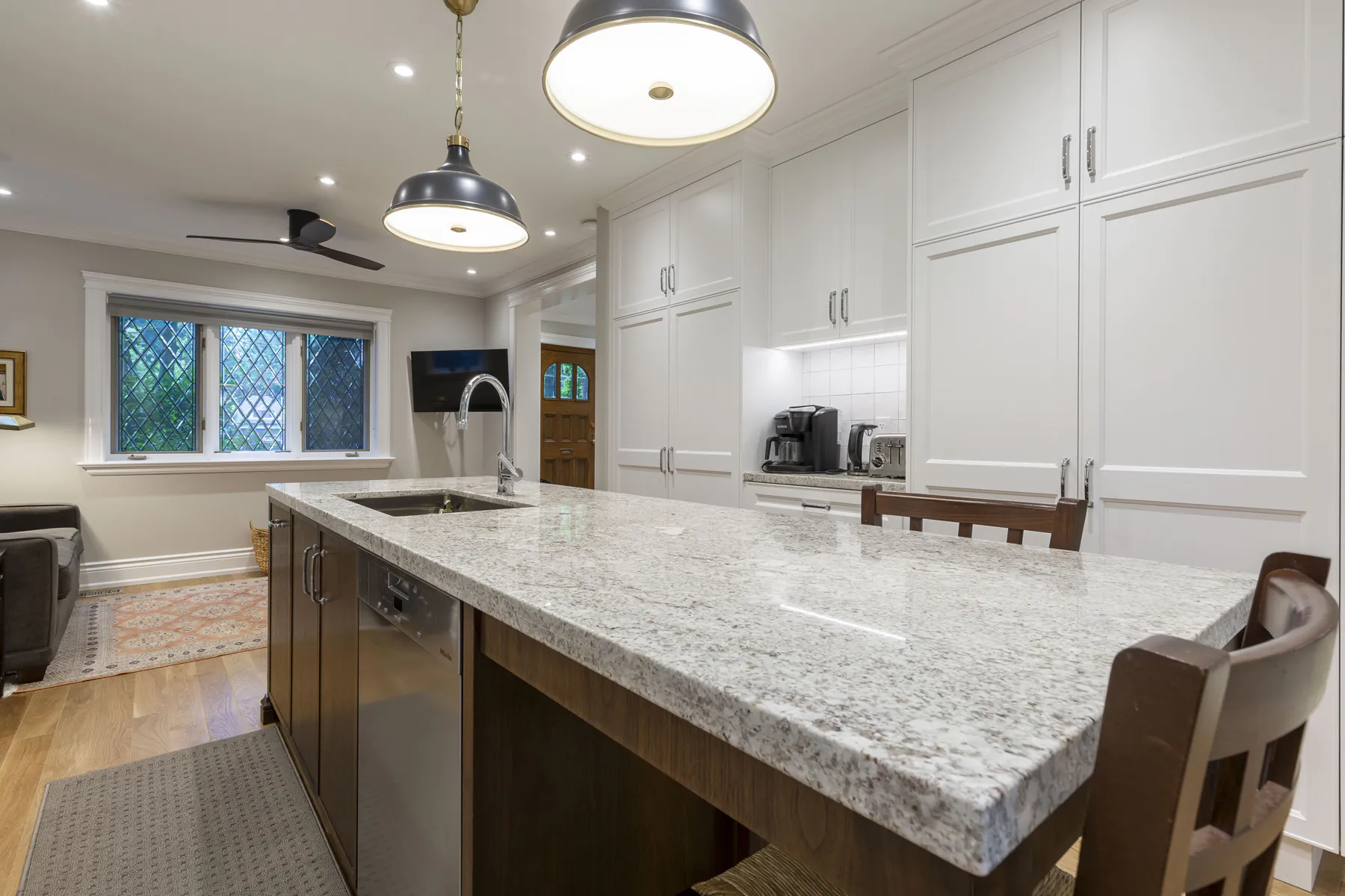 White kitchen with granite island and leaded glass window
