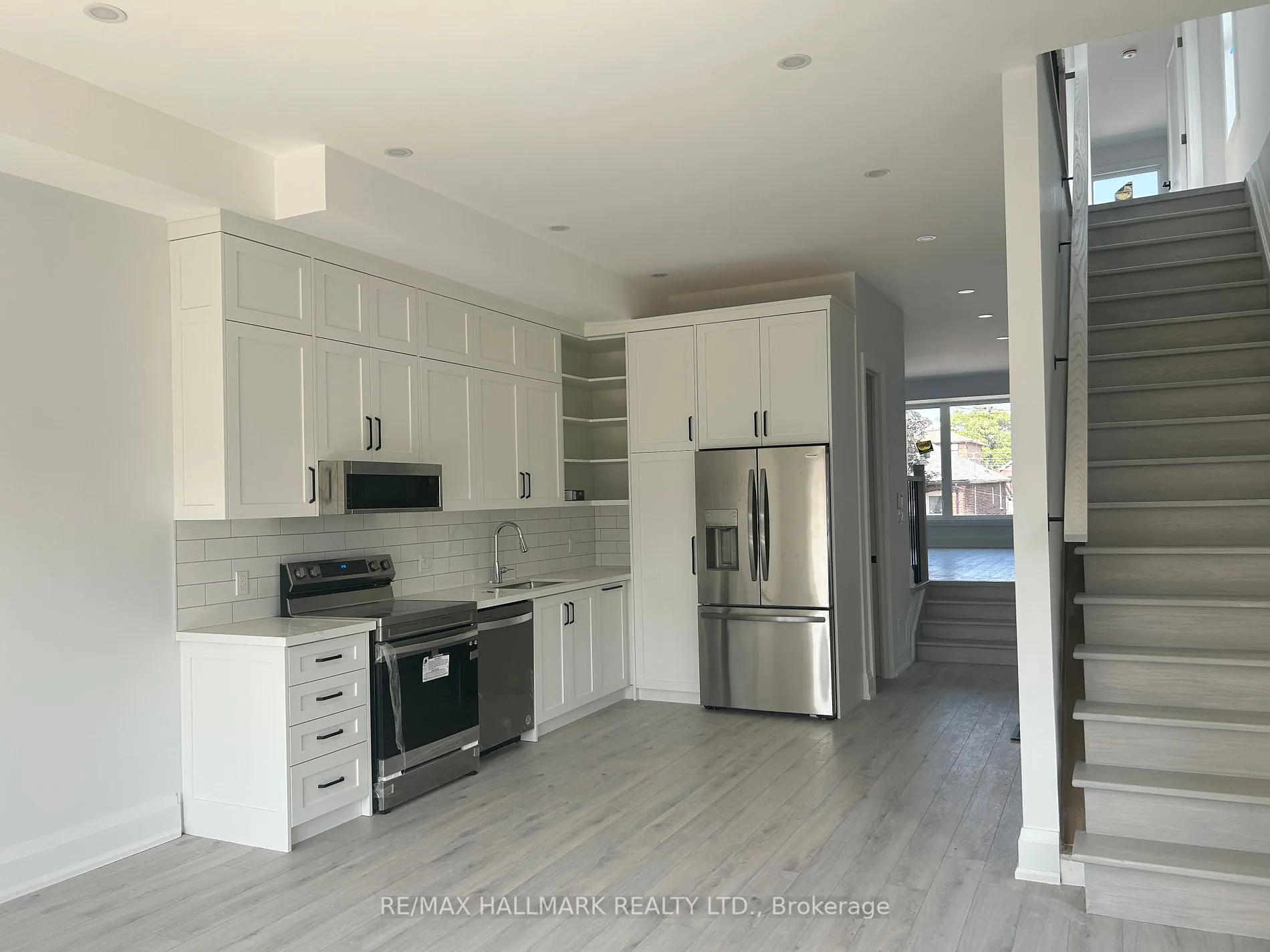 Kitchen with new appliances beside the staircase