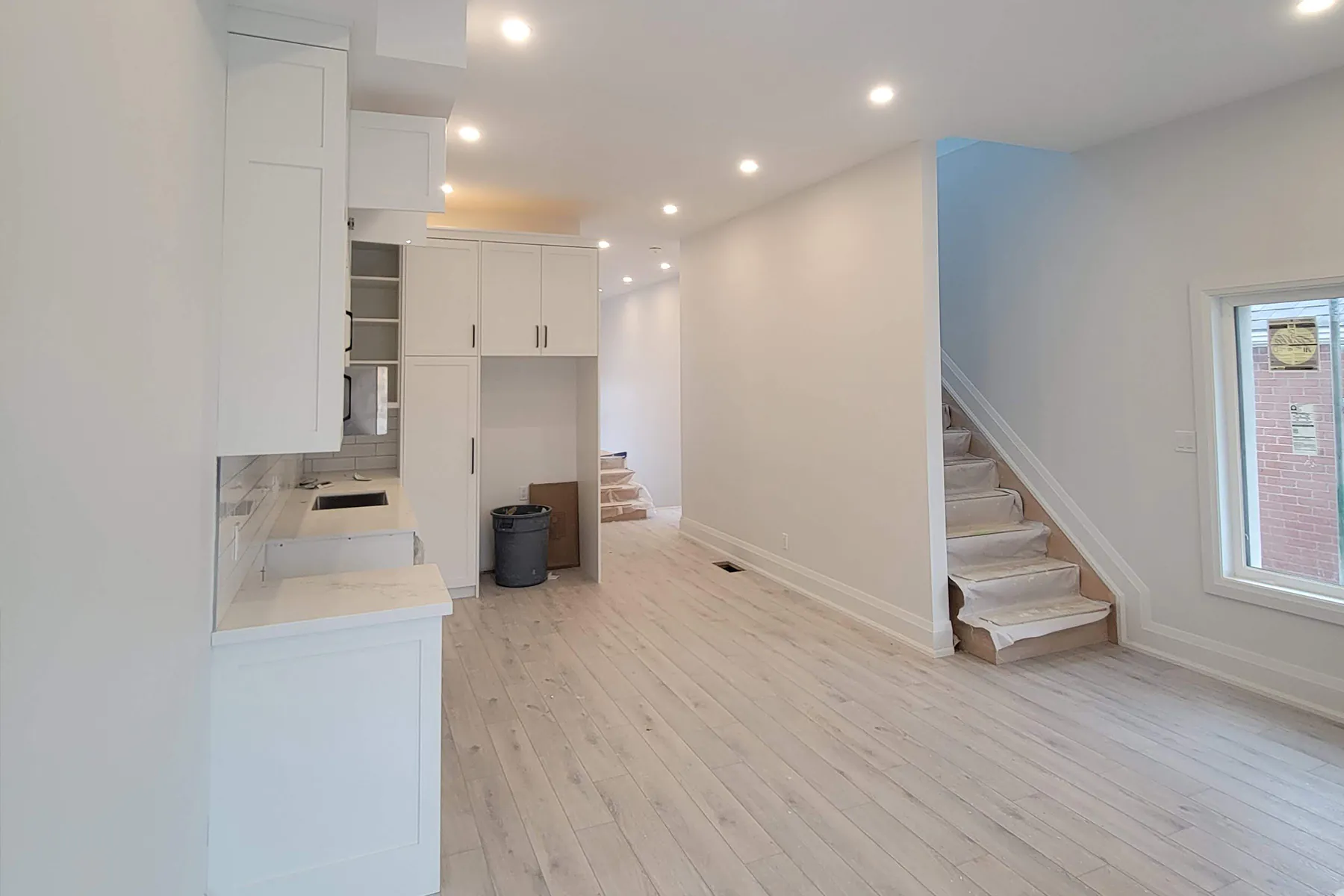 Main floor with white kitchen and new staircase
