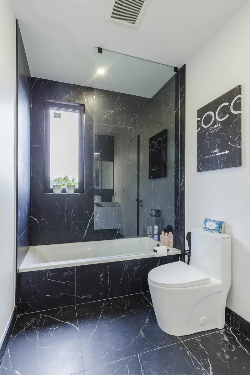 Bathroom with black marble tub and tile surround