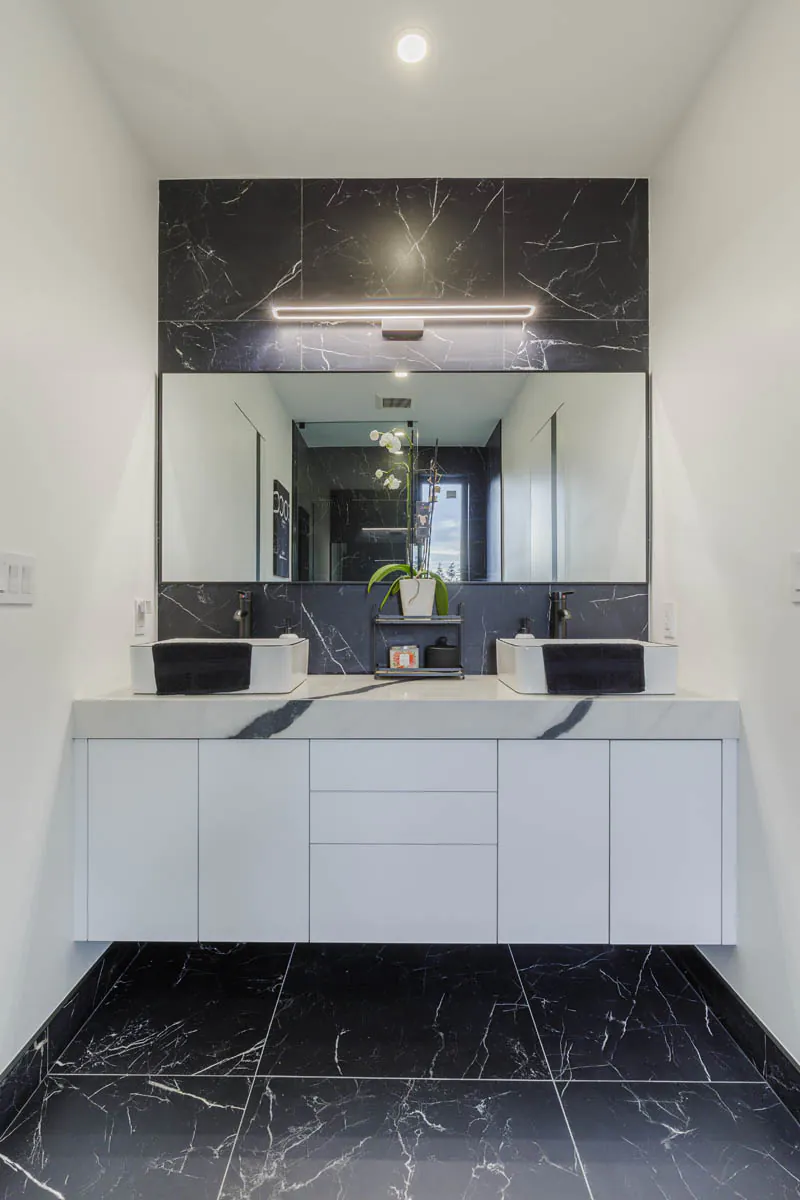 Bathroom with white designer vanity and black marble floor