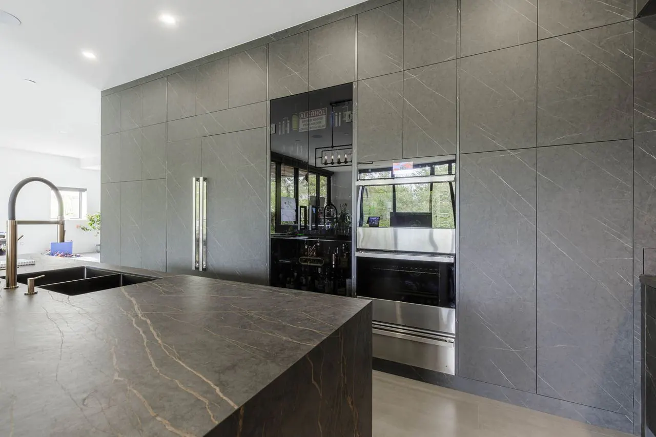 European style kitchen with dark stone island and integrated appliances
