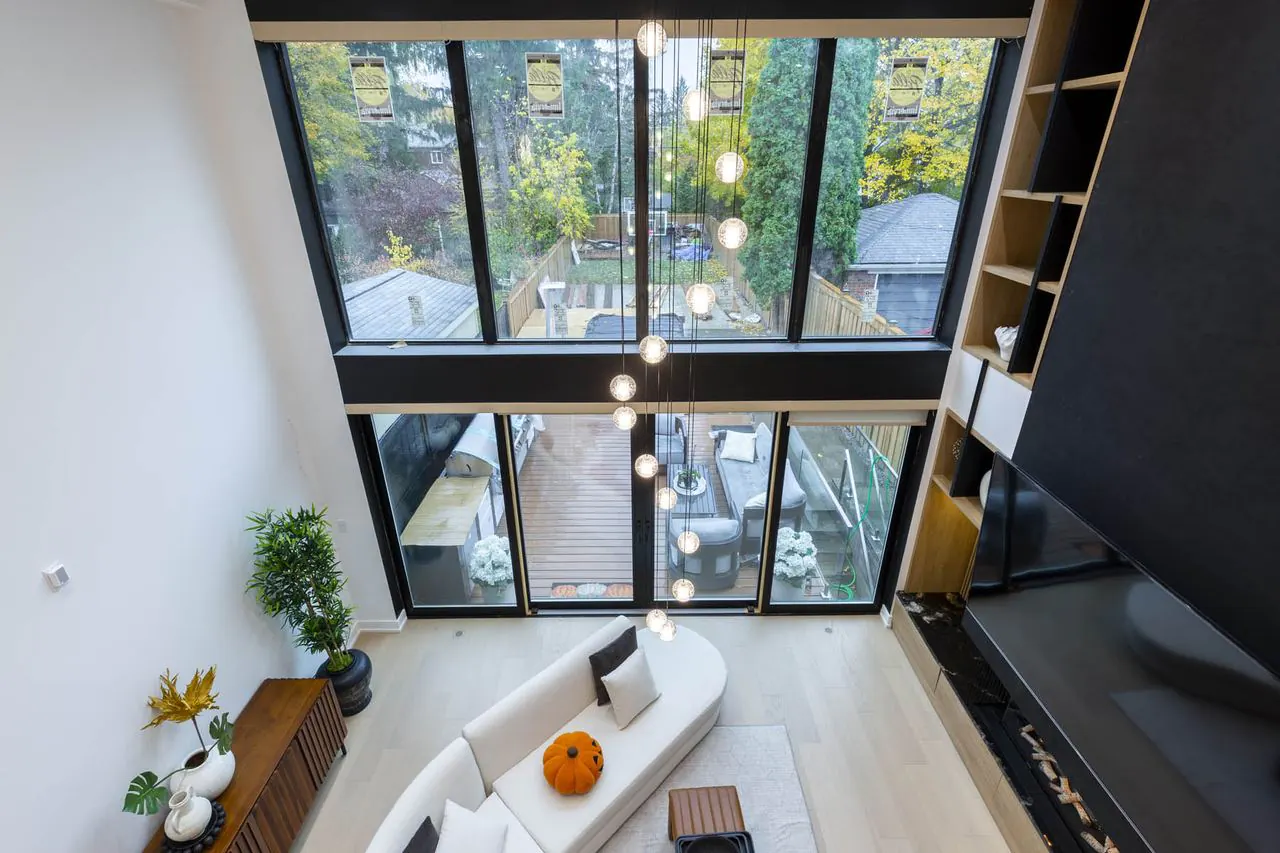 Open to above living space with full height windows and black feature wall in the Balliol St complete rebuild