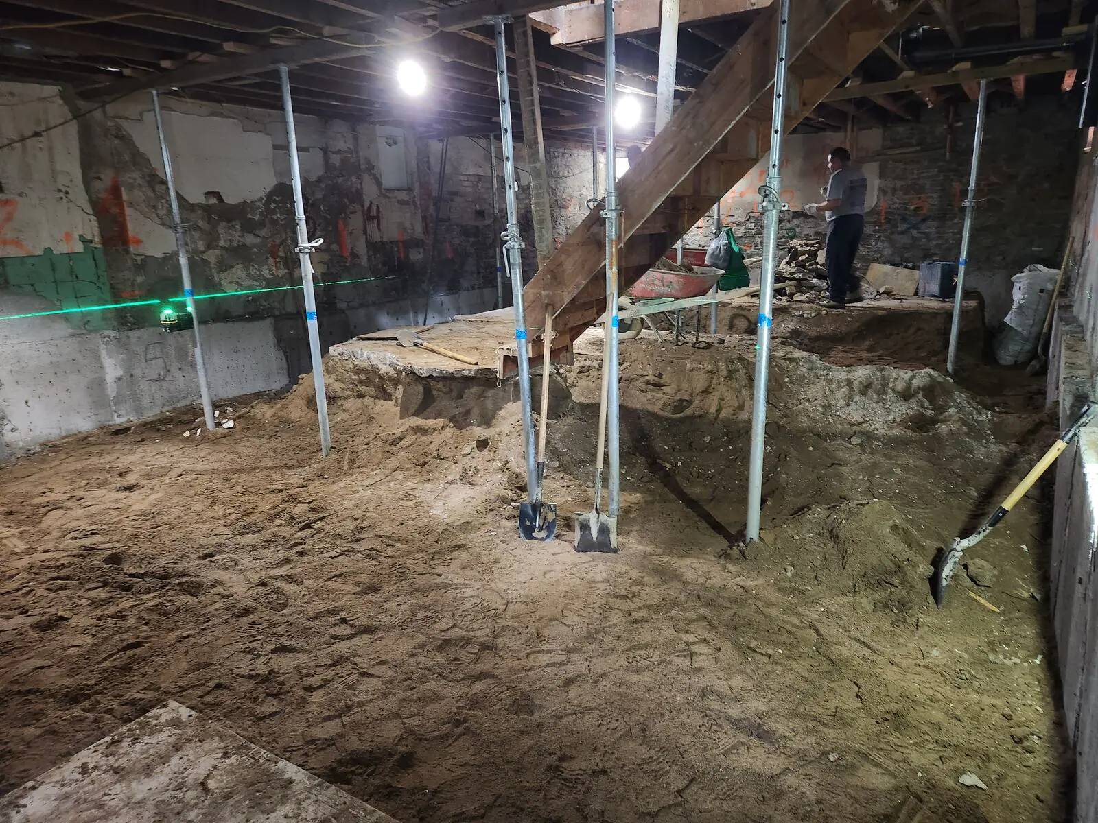 Basement underpinning excavation with laser level and shoring posts