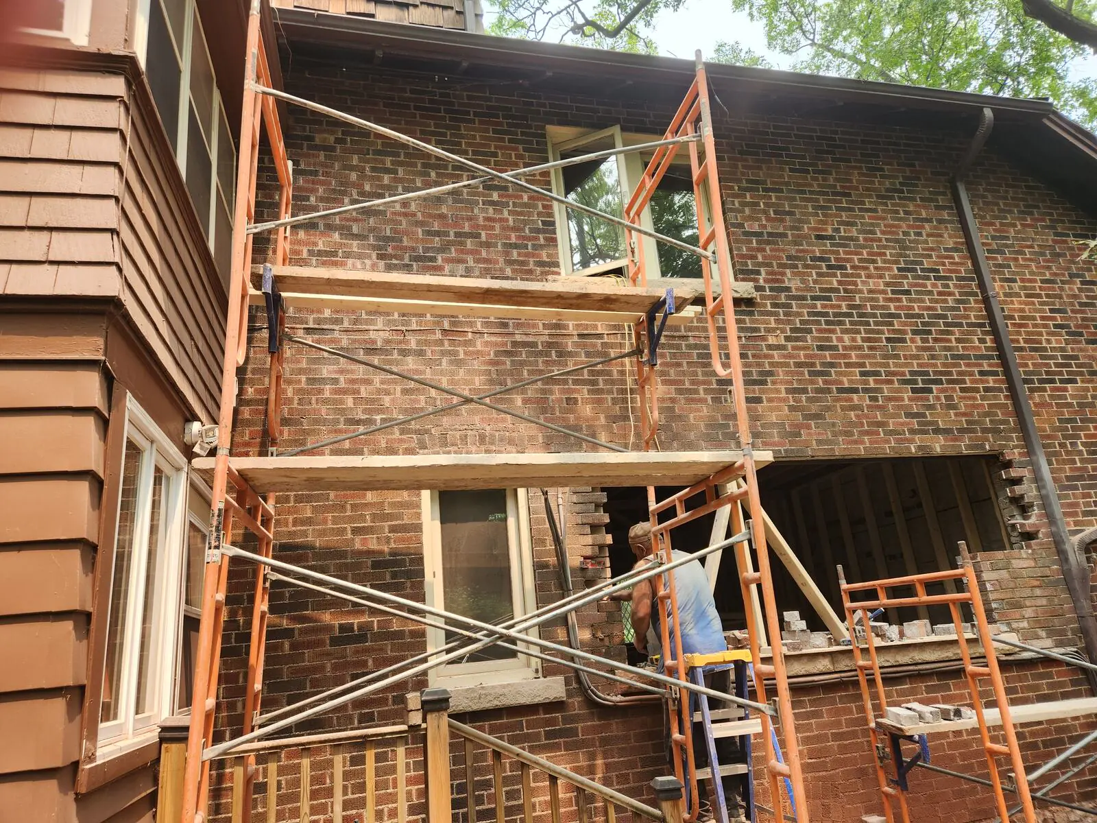 Masonry work on scaffolding during exterior brick alterations