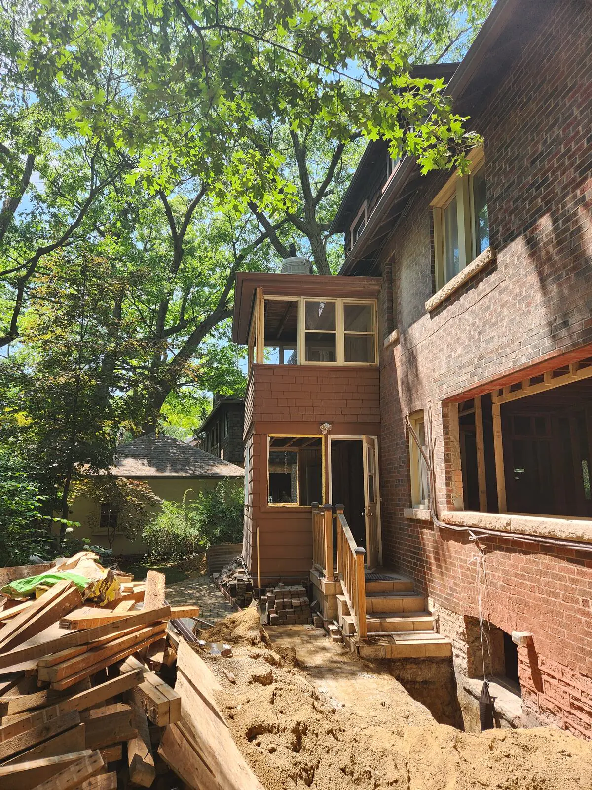 Rear exterior during construction with new window openings and excavation