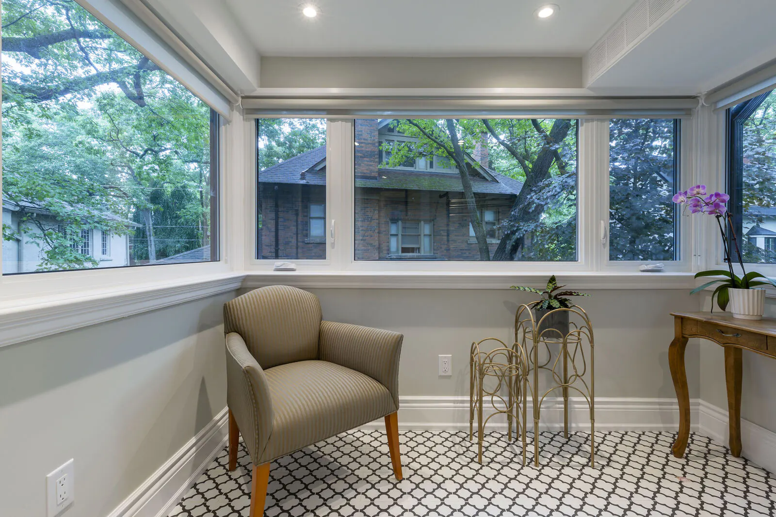 Renovated sunroom with wraparound windows and patterned tile floor