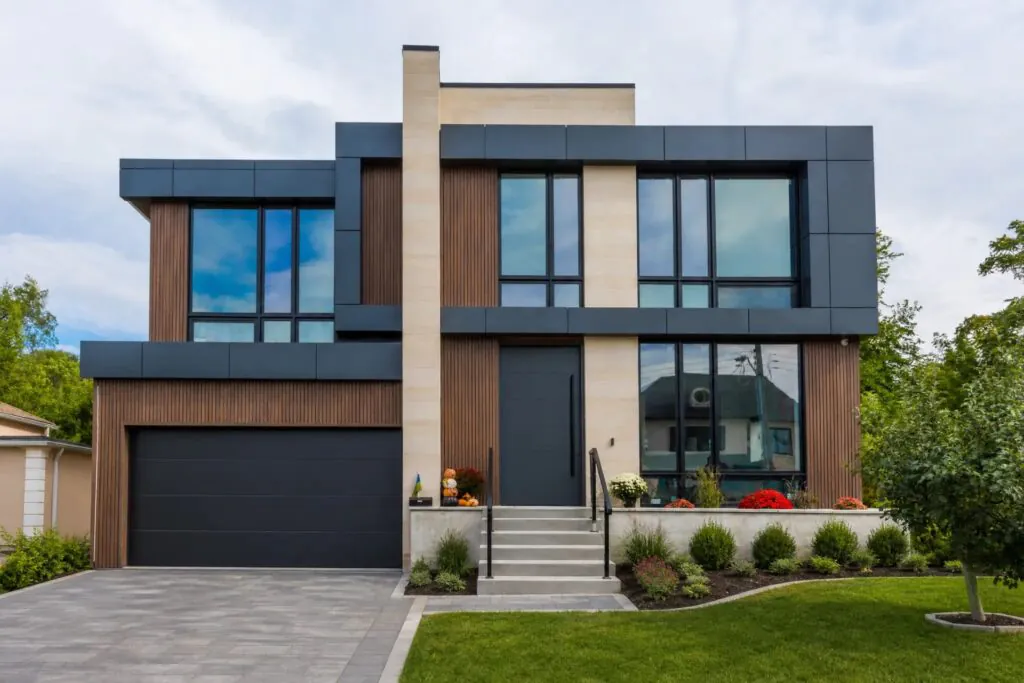 Front elevation of the completed Donnavale custom home with dark panel cladding, wood slats and double garage