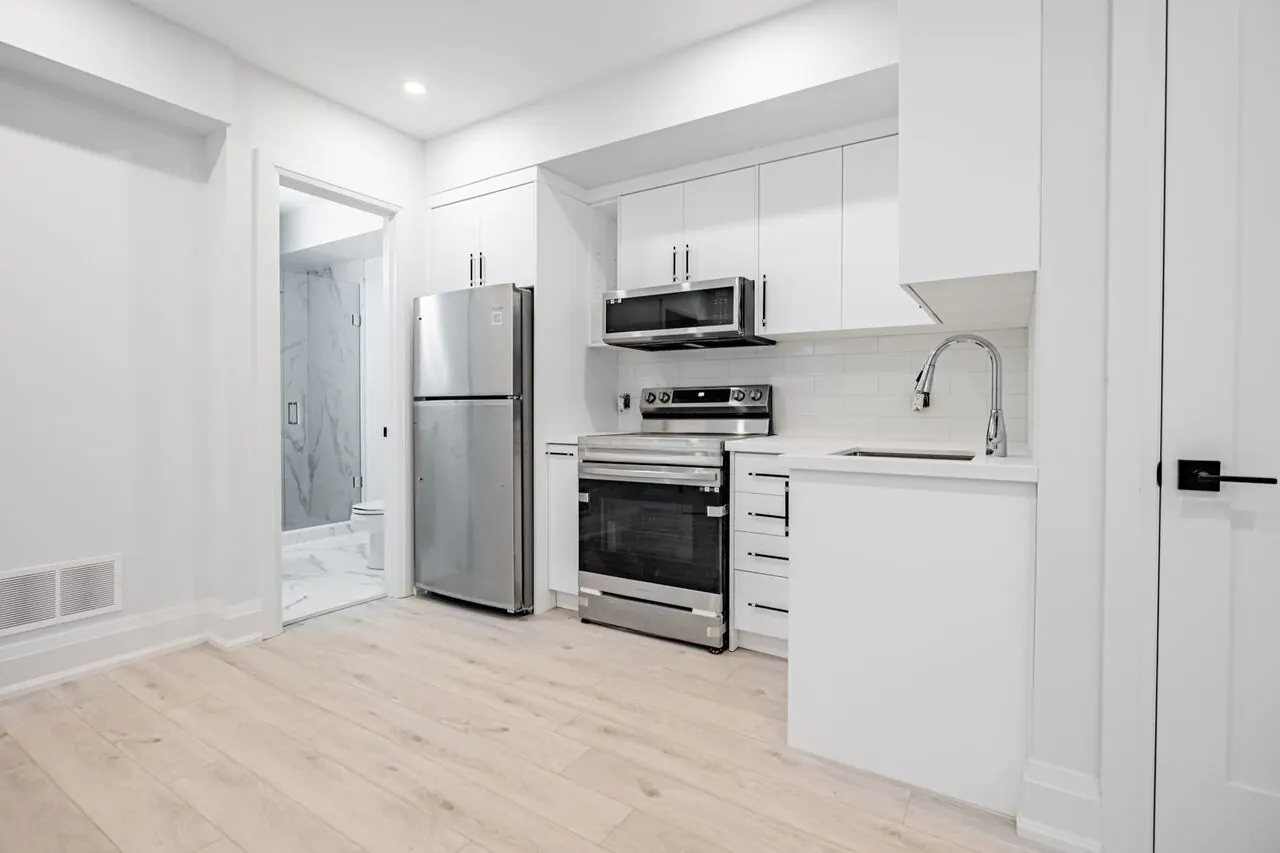 Basement suite kitchen with white cabinets and stainless appliances