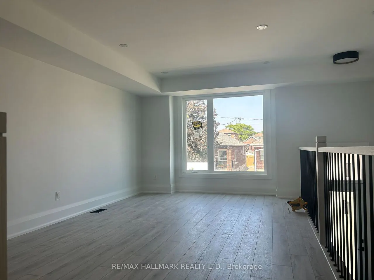 Bright upper family room with large window and railing overlook
