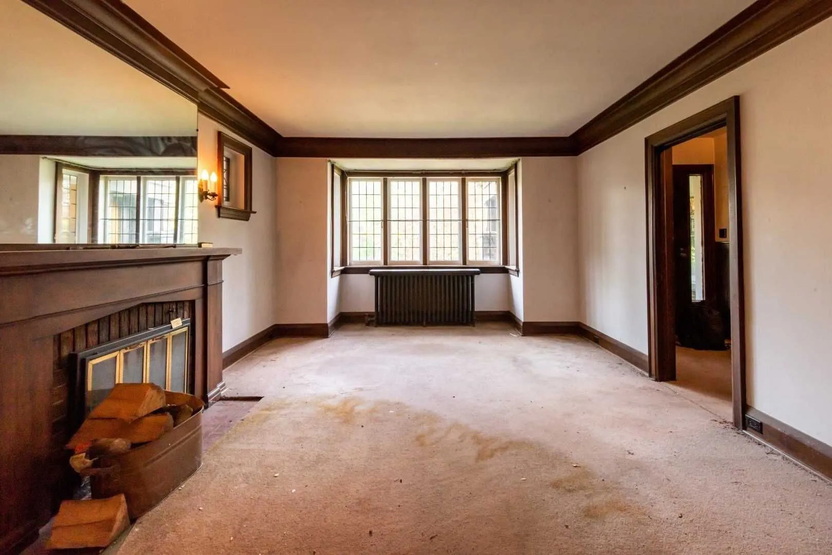 Living room before renovation with dated trim and worn carpet